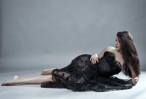 Модель в чорній мереживній сукні позує — стокове фото