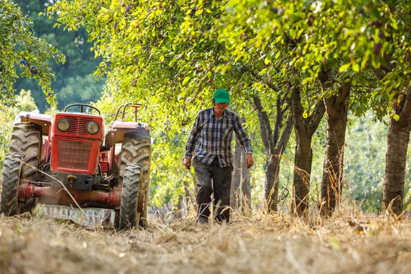 Agricultor sobre tractor con remolque — Foto de Stock