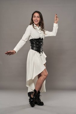 Beyaz elbiseli, çizmeli ve korseli İspanyol kadın manken.