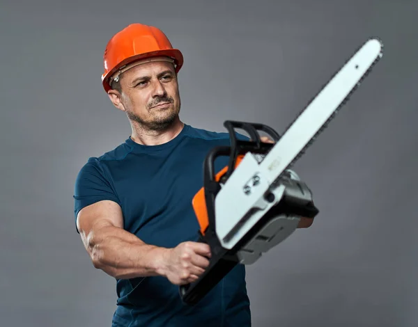 Trabajador Hardhat Sosteniendo Una Motosierra Tamaño Mediano —  Fotos de Stock