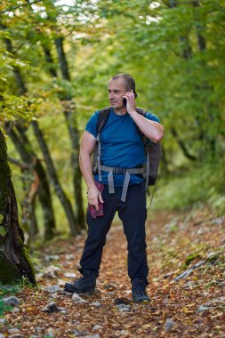Sırt çantalı bir yürüyüşçü, yol soruyor, ormanda kayboluyor.