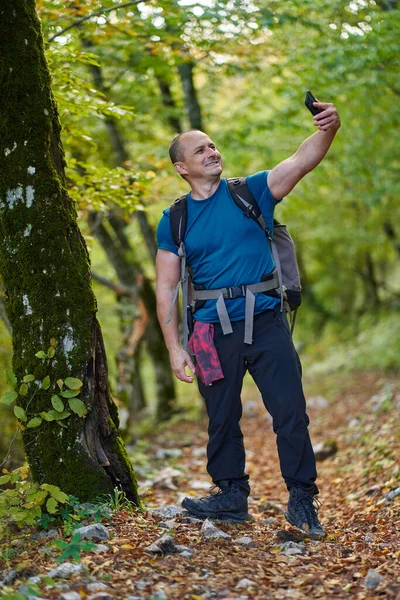 Hombre Con Mochila Tomando Selfies Mientras Camina Por Bosque —  Fotos de Stock