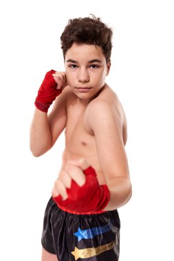 Genç kickboksçu, gölge boksu eğitimi alıyor, beyaz arka planda izole edilmiş.