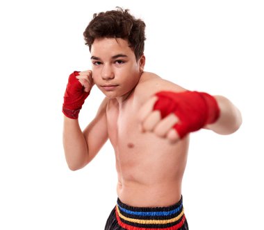 Genç kickboksçu, gölge boksu eğitimi alıyor, beyaz arka planda izole edilmiş.