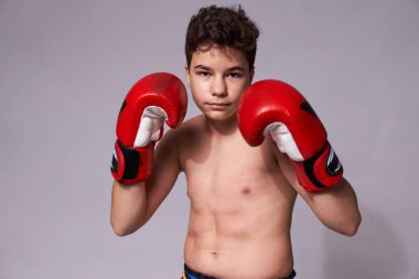 Kırmızı eldivenli genç boksör beyaz arka planda çeşitli vurgunlar yapıyor.