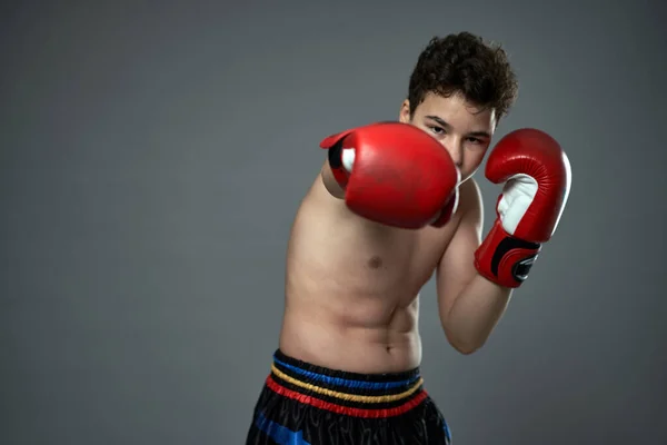 戴红色手套的年轻拳击手在灰色背景下摆出各种姿势 — 图库照片