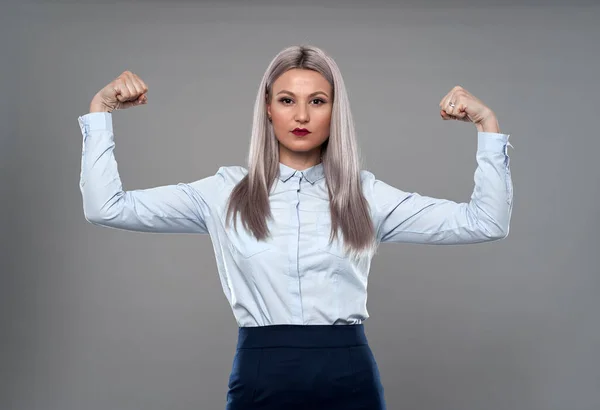 強い若い実業家が正式な服で彼女の筋肉を曲げ — ストック写真