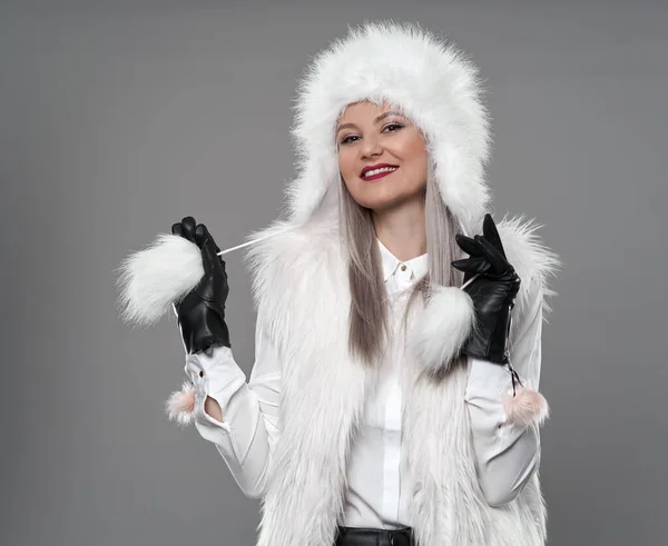 迷人的年轻女子穿着白色毛皮外套在灰色背景下过冬 演播室拍摄 — 图库照片
