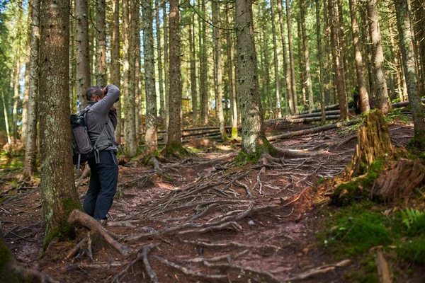 带着沉重背包 三脚架和照相机的专业自然摄影师在森林和山区徒步旅行 — 图库照片