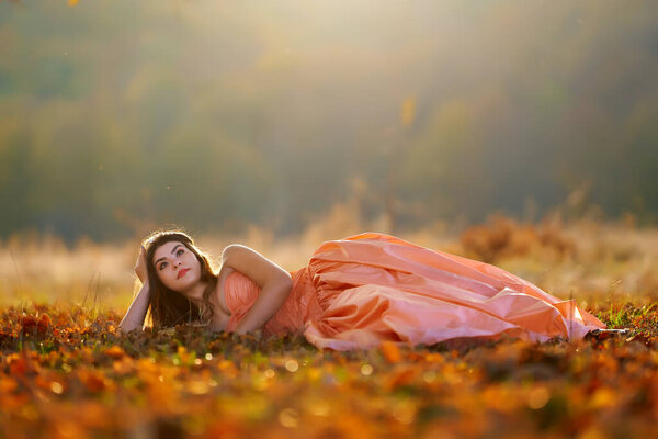 Autumnal beauty portrait of a young woman in an oak forest