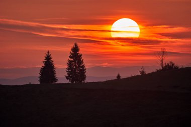 Soğuk bir kasım sabahı güneşin doğuşuyla birlikte çeşitli ormanlarla kaplı dağların manzarası.