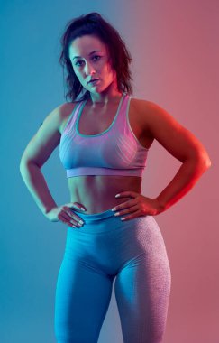 Kendine güveni tam ve beden ölçülerinde genç bir kadın stüdyoda egzersiz yapıyor. 