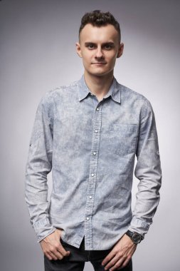 Gri arka planda genç ve yakışıklı bir iş adamı.