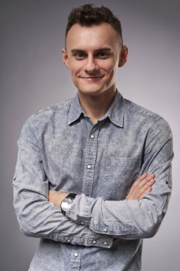 Kolları bağlı ve neşeli bir ifadeyle genç bir iş adamı