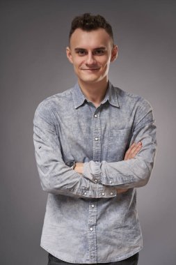 Gri arka planda yakışıklı genç bir iş adamının yakın çekimi.