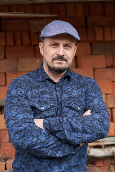 Homem Barbudo Camisa Azul Boné Por Uma Pilha Tijolos — Fotografia de Stock