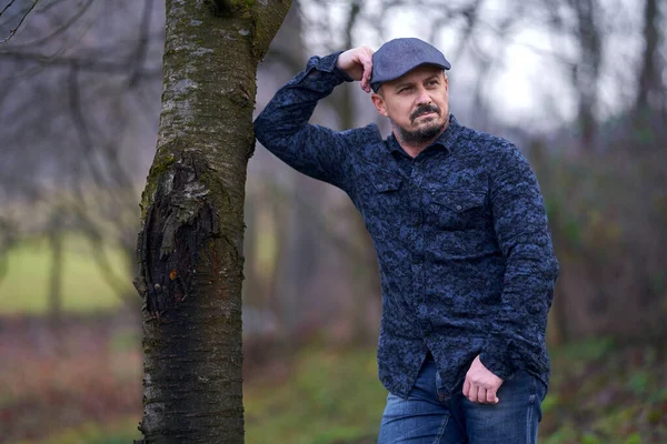 Primer Plano Agricultor Mediana Edad Con Gorra Apoyada Árbol Huerto —  Fotos de Stock