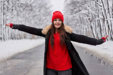 Karlı ormanda bir yolda beyaz bir kadının portresi.