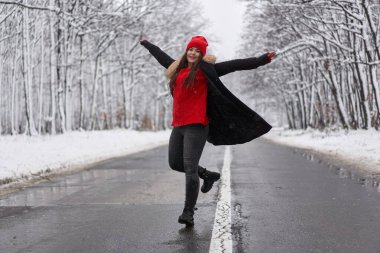 Karlı ormanda bir yolda beyaz bir kadının portresi.