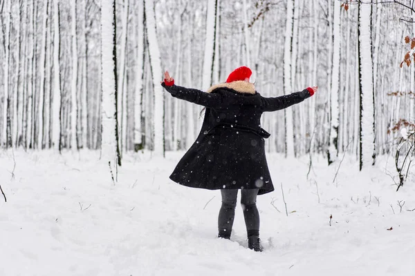 冬季雪地森林里头戴红帽的年轻高加索女人的画像 — 图库照片