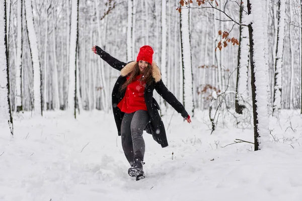 冬季雪地森林里头戴红帽的年轻高加索女人的画像 — 图库照片