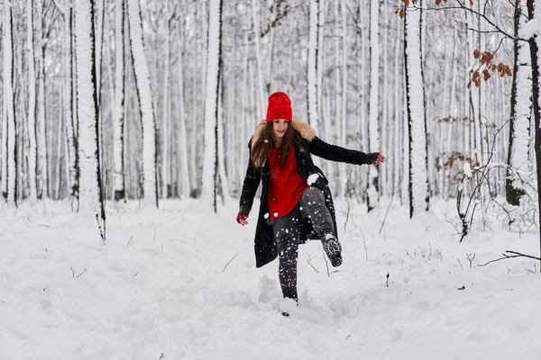 冬季雪地森林里头戴红帽的年轻高加索女人的画像 — 图库照片