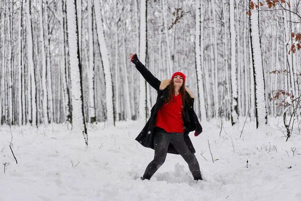 冬季雪地森林里头戴红帽的年轻高加索女人的画像 — 图库照片