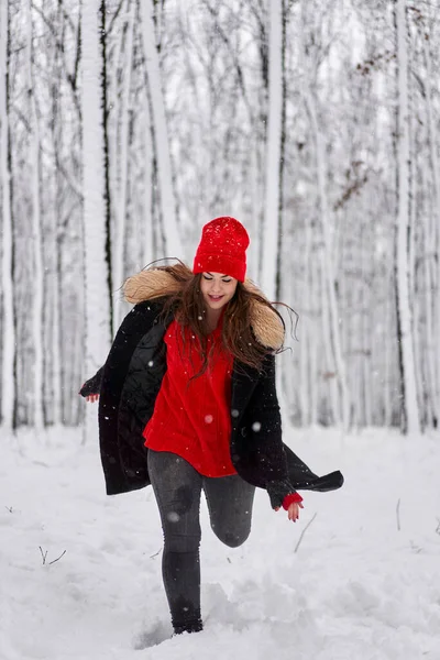 冬季雪地森林里头戴红帽的年轻高加索女人的画像 — 图库照片