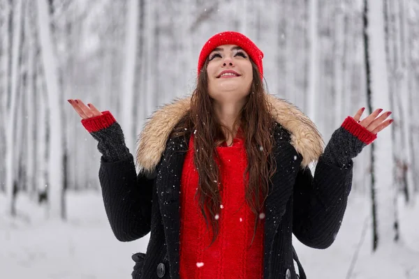 冬季雪地森林里头戴红帽的年轻高加索女人的画像 — 图库照片