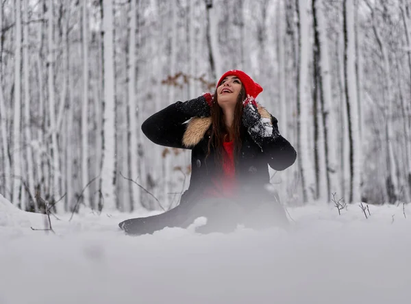 冬季雪地森林里头戴红帽的年轻高加索女人的画像 — 图库照片