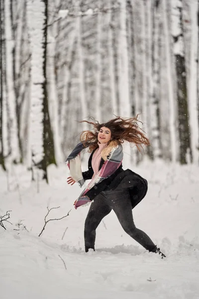 若い白人女性は森の中で雪遊びを楽しんでいます — ストック写真