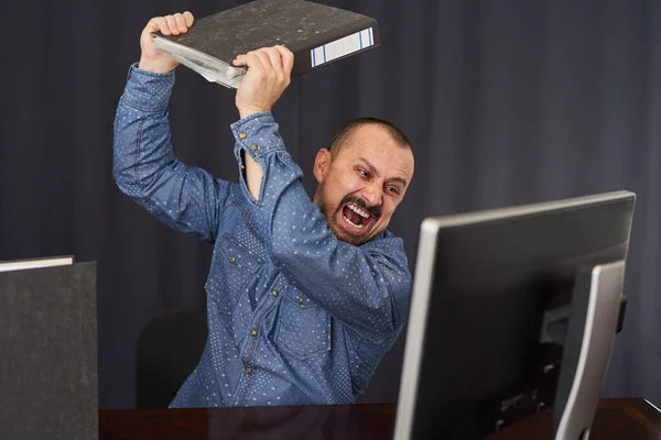 怒っているビジネスマンは 文書のフォルダとコンピュータの画面をスマッシング — ストック写真