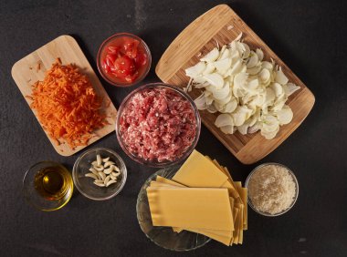 Tahta üzerinde lazanya tarifi malzemelerinin olduğu düz bir kare.