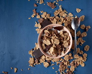 Yulaf gevreği ve sıcak sütlü bir kasede çikolata.