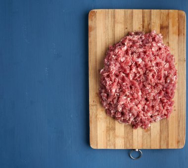 Kıyılmış domuz eti bir ahşap tahta üzerinde closeup