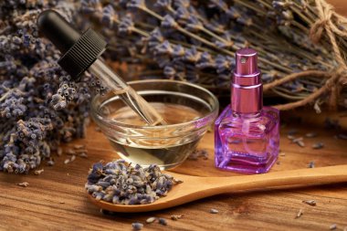 Lavender essential oil, aromatic water and dried flowers in closeup clipart