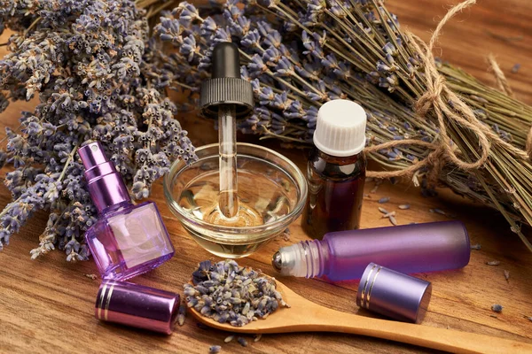 Lavender essential oil, aromatic water and dried flowers in closeup