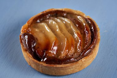 Mavi ahşap arka planda çikolatalı armutlu turta.