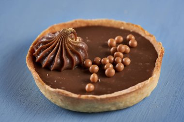 Mavi ahşap arka planda çikolatalı tart