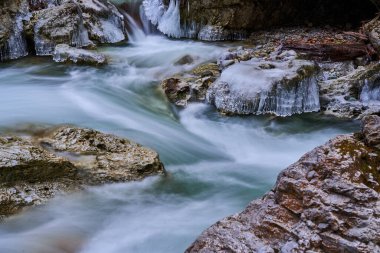 Kışın vadiden akan nehirdeki buz saçakları.