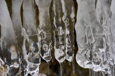 Kışın vadiden akan nehirdeki buz saçakları.