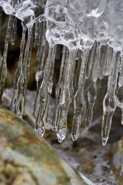 Kışın vadiden akan nehirdeki buz saçakları.