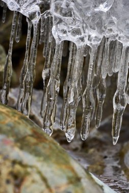 Kışın vadiden akan nehirdeki buz saçakları.