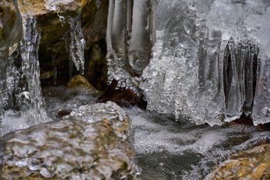 Kışın vadiden akan nehirdeki buz saçakları.