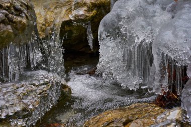 Kışın vadiden akan nehirdeki buz saçakları.