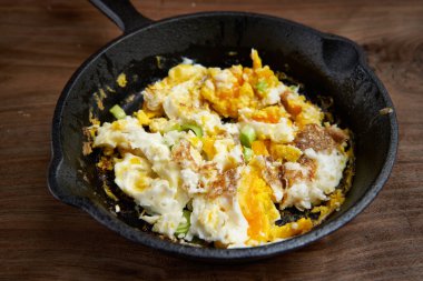 Tahtadaki dökme demir tavada çırpılmış yumurta.