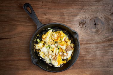 Tahtadaki dökme demir tavada çırpılmış yumurta.