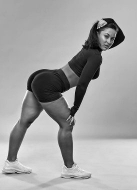 Ayrıca kendine güvenen genç bir kadın gri arka plan üzerinde spor yapıyor.