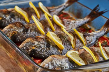 Oven baked broiled bream with vegetables and lemon
