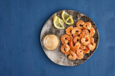 Lezzetli kırmızı kral karidesleri wok 'ta mavi arka planda hazırlandı.